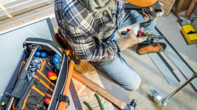 a-construction-worker-uses-a-toolbox-while-install-2025-03-15-18-44-58-utc.jpg